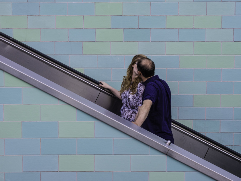 A couple kissing on an escalator - before