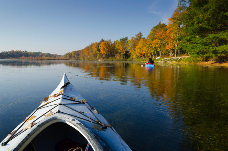 Before: A canoe bow fill foreground of a photo across a lake.