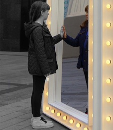 Girl touching a mirror