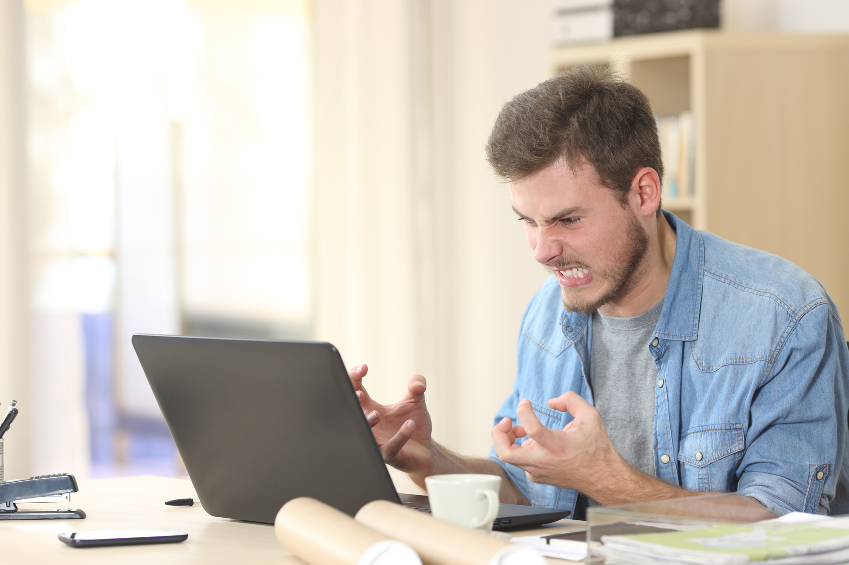 Stock photo of man angry at computer